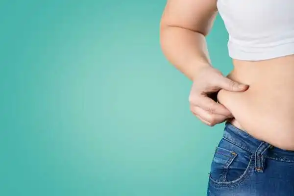 Image of woman pinching her love handles to show weight gain Midhurst