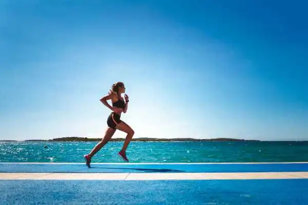 Woman running showing strong leg muscle Midhurst
